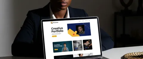 A career professional with her portfolio website loaded on a laptop placed on a table she is sitting on